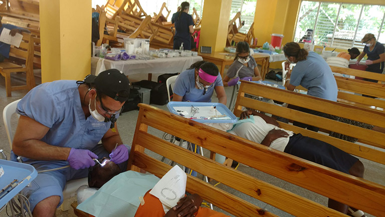 student dentists treat patients in a local clinic
